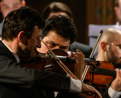 three violin players concentrating on playing, part of Hastings Philhamonic Orchestra
